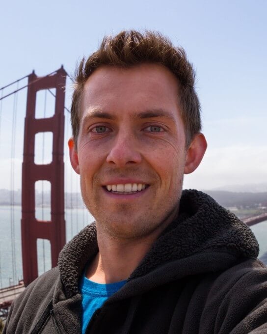 a man in dark casual outfit with his back to the bridge