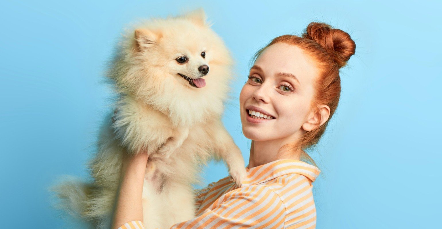 A young woman holding a cute dog