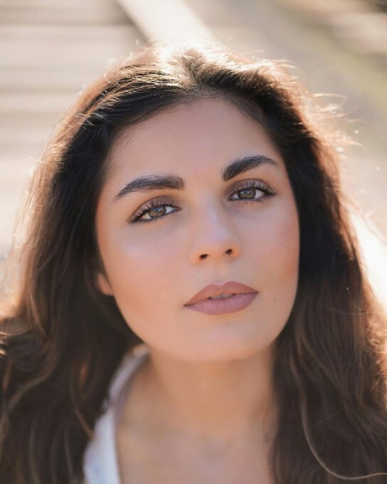 selfie of a female with long brown curly hair